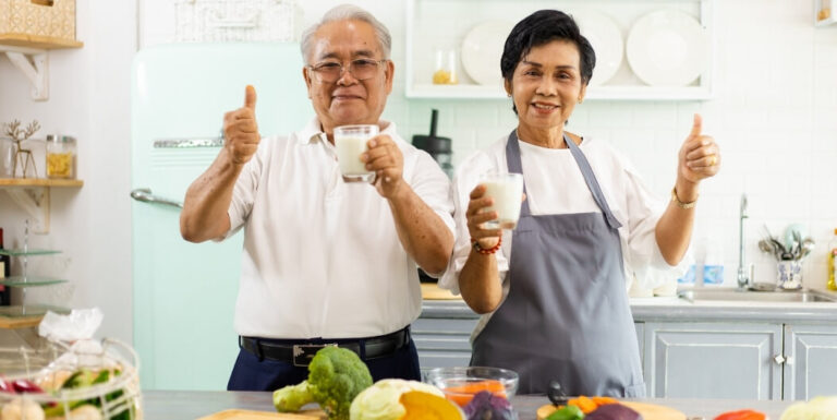 Elderly Couple Holding Glasses of Milk in Memory Care