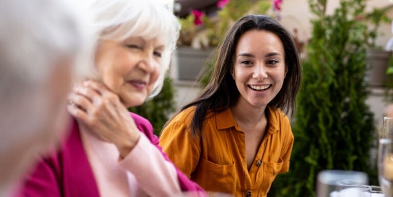 Young Woman Visiting Elderly Family Members Outdoors at an Assisted Living Facility